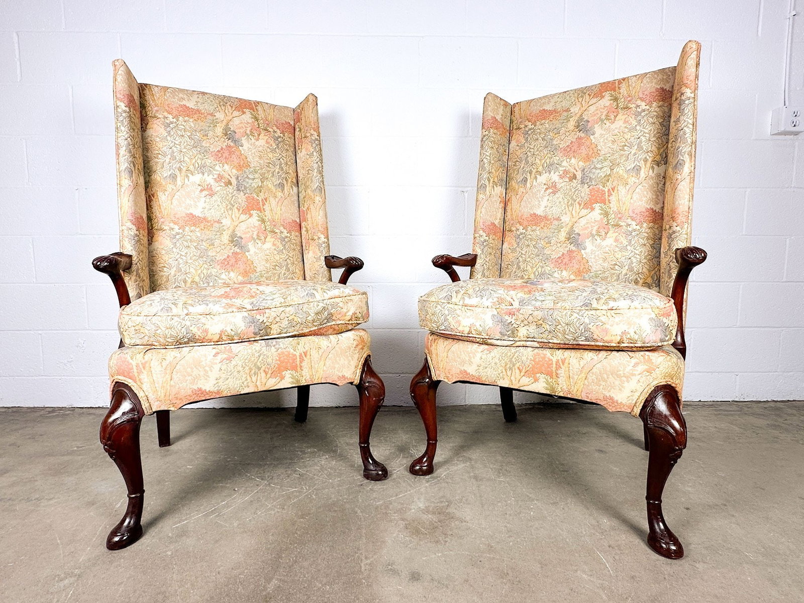Pair of Queen Anne Style Wingback Armchairs with Tree Motif Upholstery: Multicolor tree motif upholstery. Carved detail on legs and armrests. Dimensions: Each chair is approx. 48 in H x 29 in W x 24 in D. LOCAL PICK UP INFORMATION: Wednesday, July 8, 10:00 AM - 2:00 PM 80
