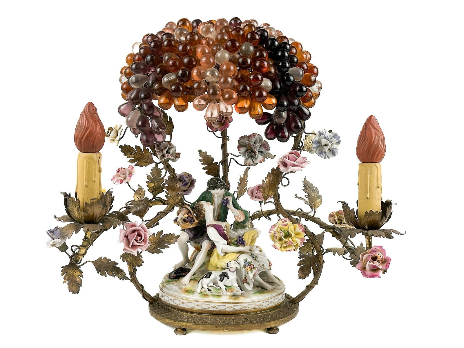 Antique Continental Porcelain Mounted Candelabra Lamp: Depicts a figural scene of a couple with a dog, decorated with encrusted flowers and a large cluster of glass grapes. One faux candle on each side of the scene with porcelain painted flowers throughou