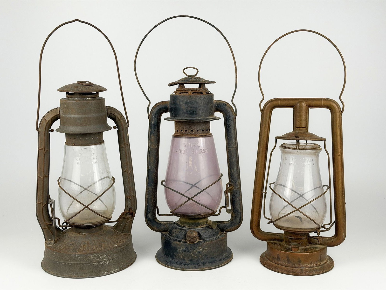 Lot of Three Dietz Antique Lanterns: Varying models, two blizzard and one monarch. Constructed of metal and glass. Sizes range between 13.25 in H x 7.5 in W x 5.75 in D and 16 in H x 8.25 in W x 6.25 in D with handles lowered. Total weig