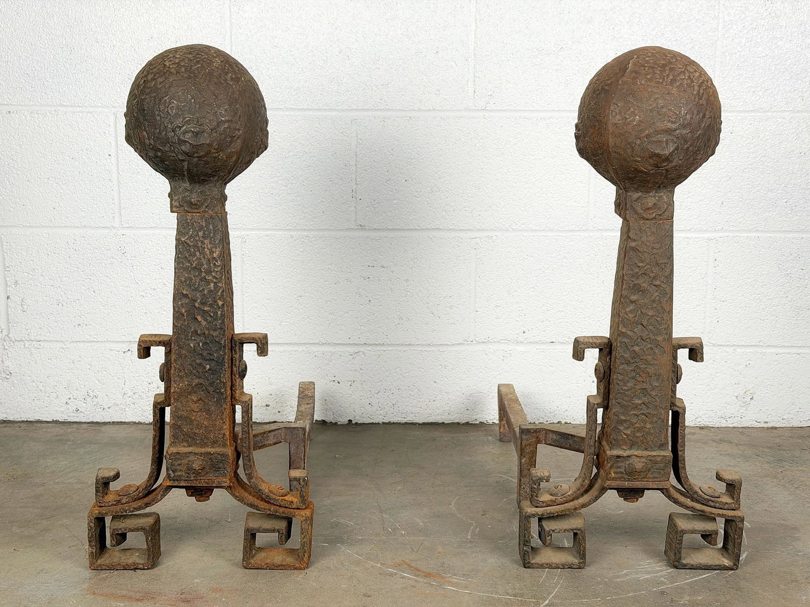 Pair of Arts & Crafts Cast Iron Andirons with Cannonball Finials and Greek-Key Feet: Features hammered texture and a large cannonball finial. Each is approximately 35.5 in H x 10.5 in W x 22 in D. LOCAL PICK UP INFORMATION: Wednesday, July 8, 10:00 AM - 2:00 PM 8059 Foothill Blvd, Sun