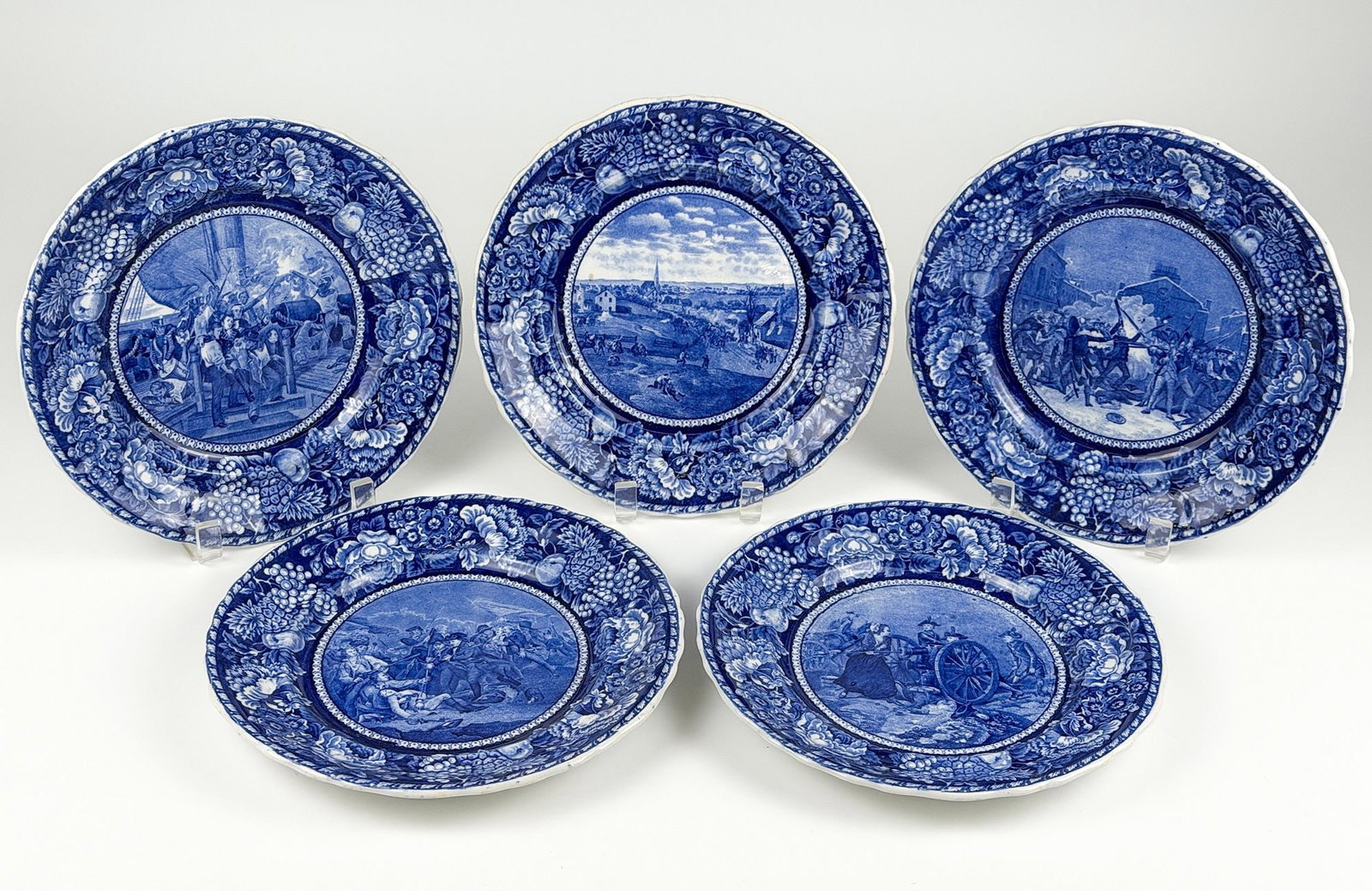 Historical Staffordshire Blue Transferware Plates, American Revolution, War of 1812: Battle commemoration plates depict various scenes from well known battles throughout United States history. Made in England. Each plate is approximately 10 in H x 10 in W. Total weight is approximatel
