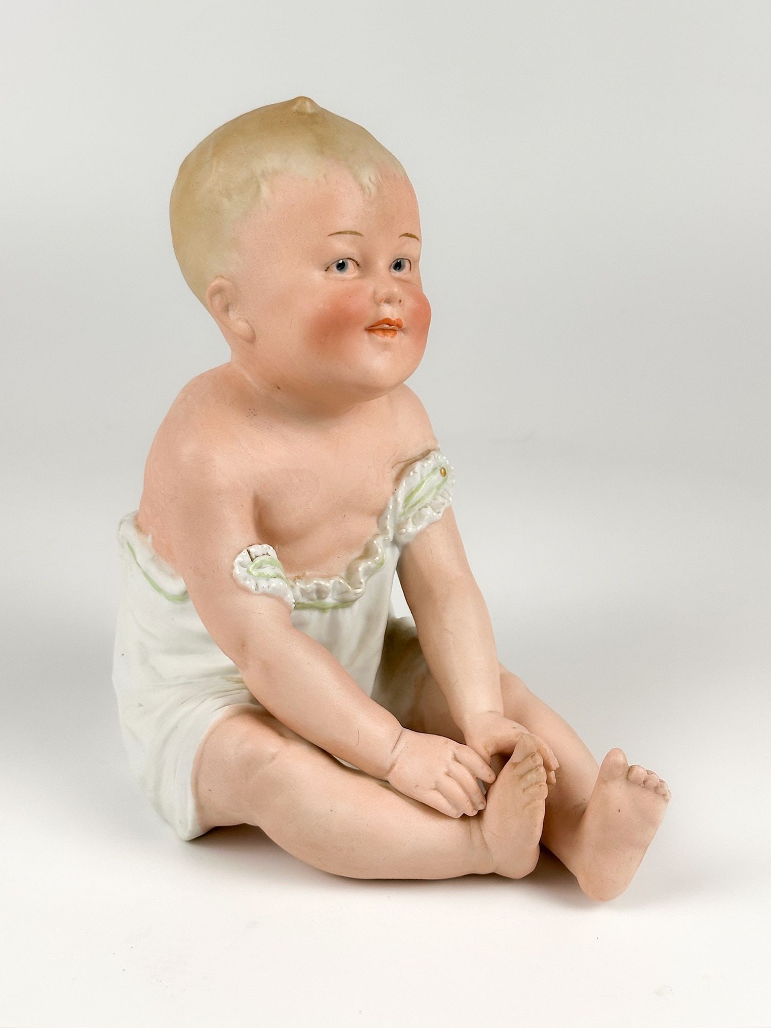 Vintage Gebruder Heubach Porcelain Piano Baby Figurine, Germany: Bisque porcelain figurine depicts a seated baby. Made in Germany. Seal on the lower back. Approximately 8 in H x 4.25 in W x 7 in D. Weighs approximately 1 lbs 10 oz. LOCAL PICK UP INFORMATION: Wednes