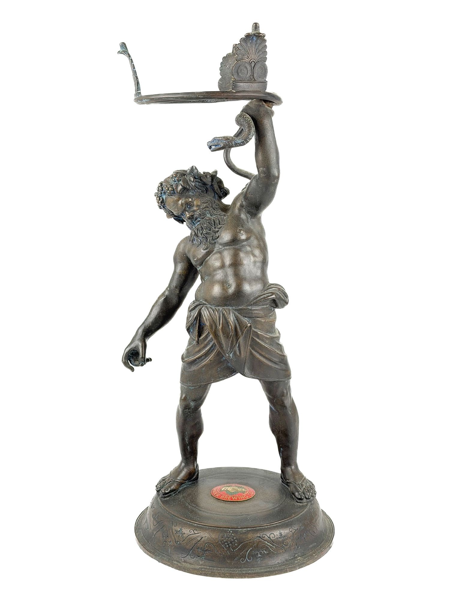 Antique Bronze Silenus Sculpture with Maier Brewing Emblem: Sculpture depicts Silenus, the satyr personifying drunkenness who adopted Dionysus. Replica of a Roman bronze unearthed in Pompeii in 1863. preserved in the Archaeological Museum of Naples. Enamel emb