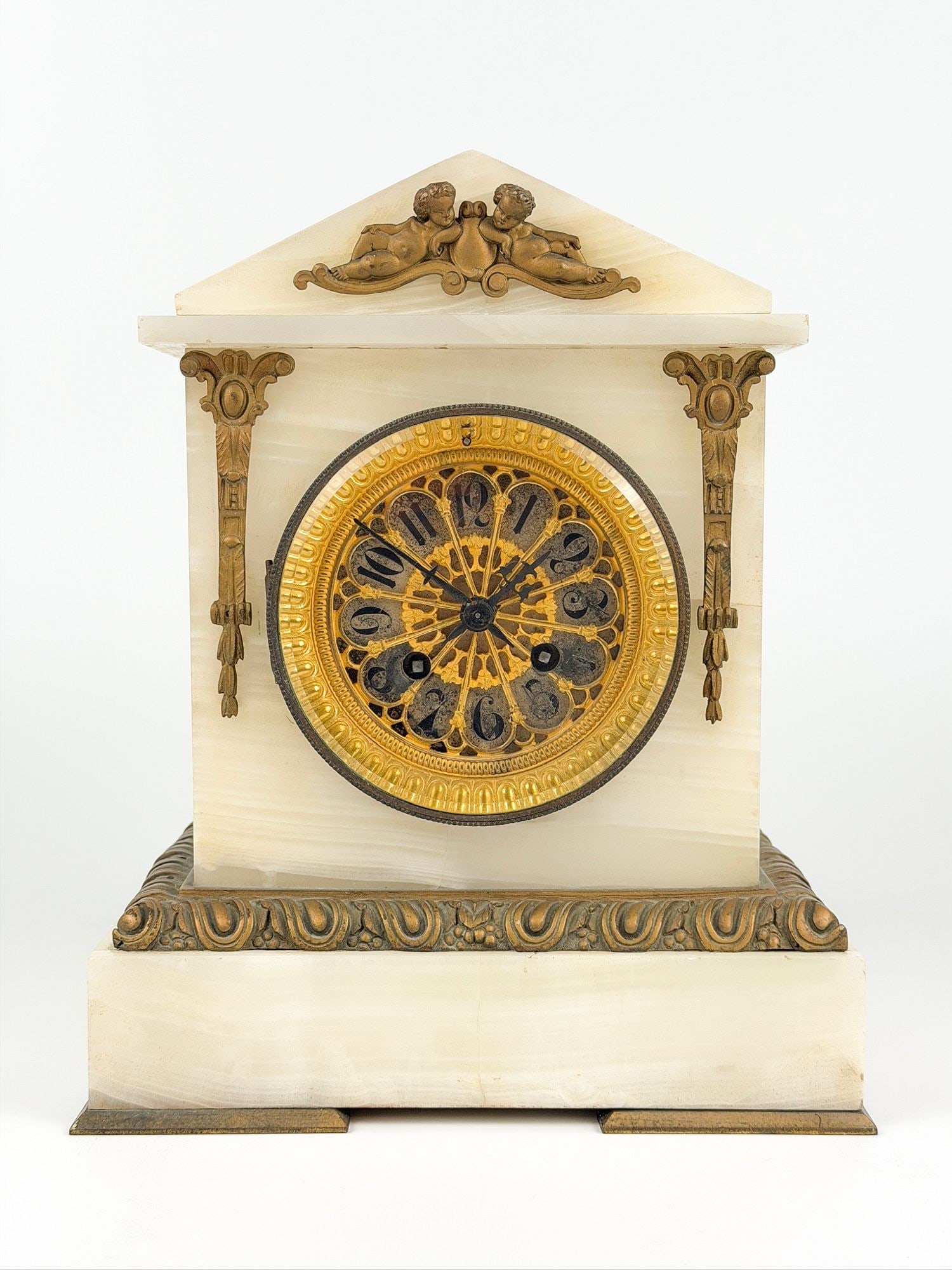 Antique Marble and Gilt Bronze Mantel Clock with Cherub Motifs: Made of marble and gilt-bronze decorative and cherub motifs. Glass face and back are hinged. Key included. Approximately 10.75 in H x 9 in W x 6 in D. Weighs approximately 19 lbs. LOCAL PICK UP INFORM
