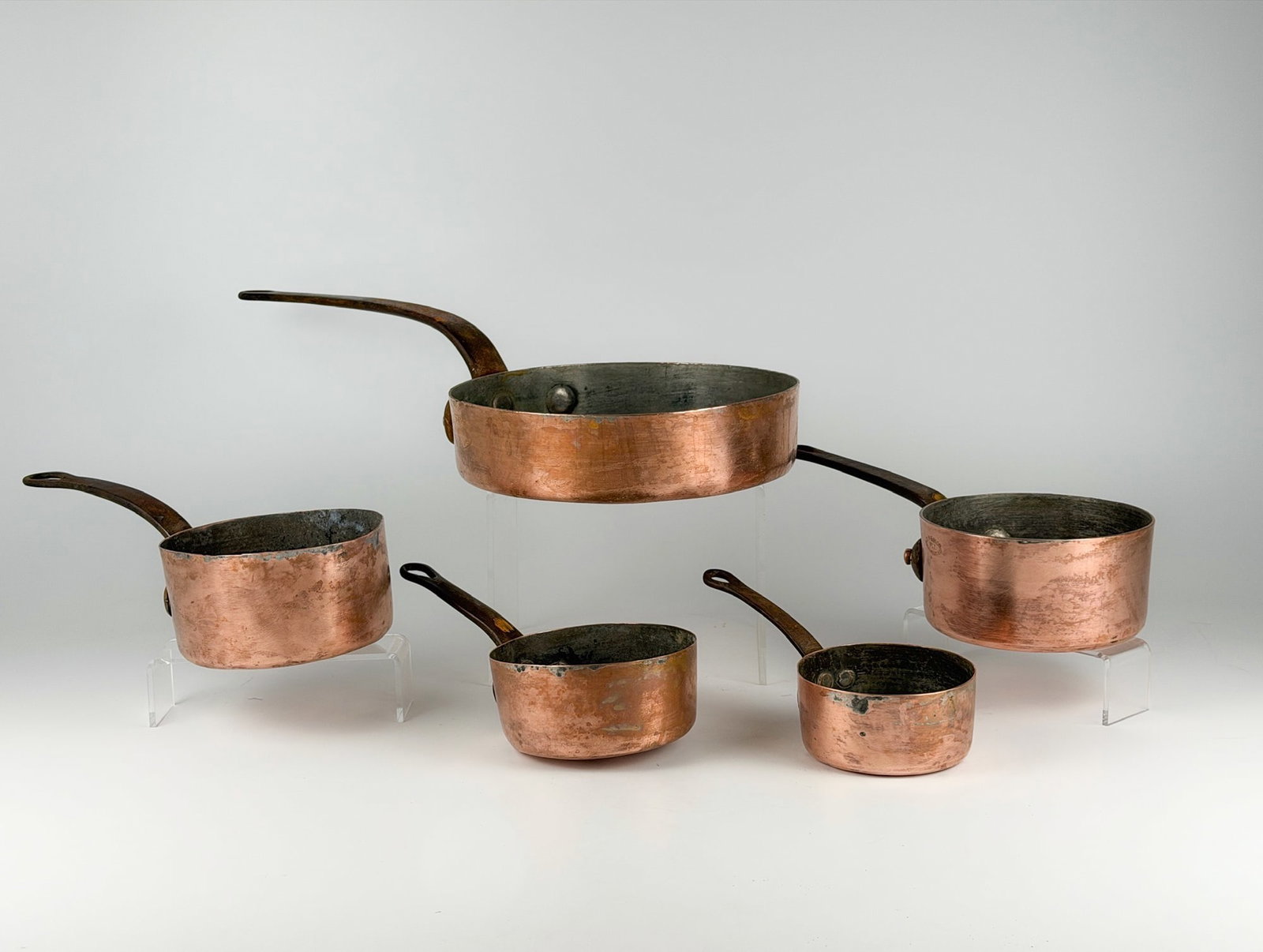 Set of 5 Antique Tin-Lined Copper Saucepans, Iron Handles, Duparquet & Morandi-Proctor: Set includes pieces made by Morandi-Proctor Company and Duparquet, Huot & Moneuse. Sizes range from approximately 2.25 in H x 9 in W x 4.5 in D to 2.5 in H x 22.5 in W x 10.25 in D. Total weight is ap