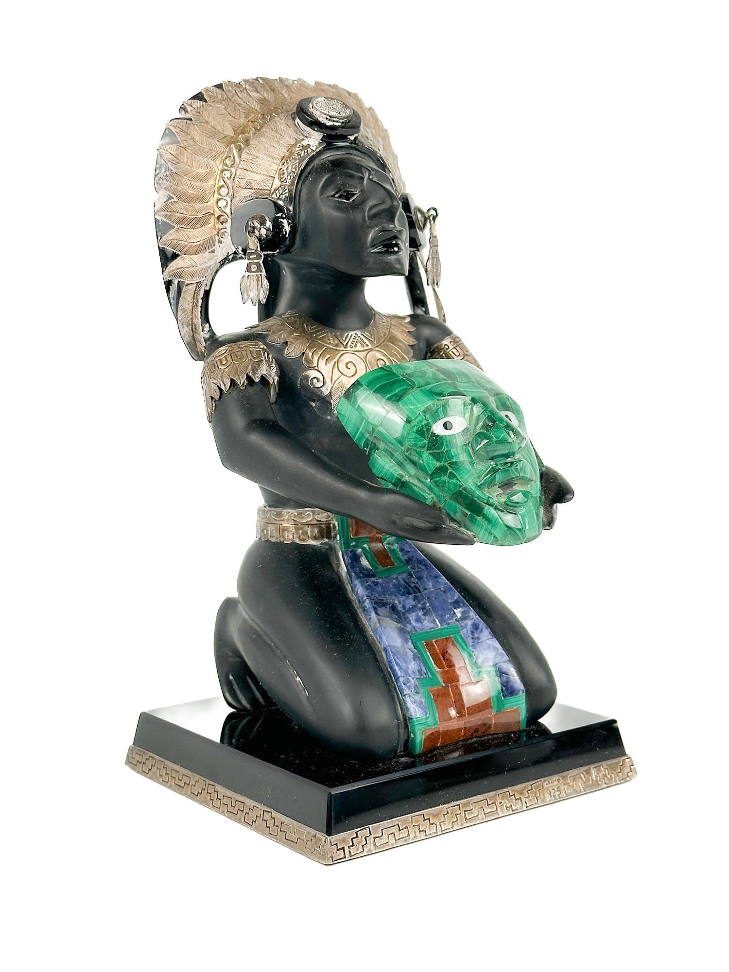 Taxco Mexican Obsidian, Sterling Silver, and Malachite Sculpture of Kneeling Figure: “Mexico 925” marking on front of base. Depicts kneeling figure holding a mask. Sticker on bottom has the name “Guerrero”. Dimensions: Sculpture is approx. 10 in H x 5 in W x 5 