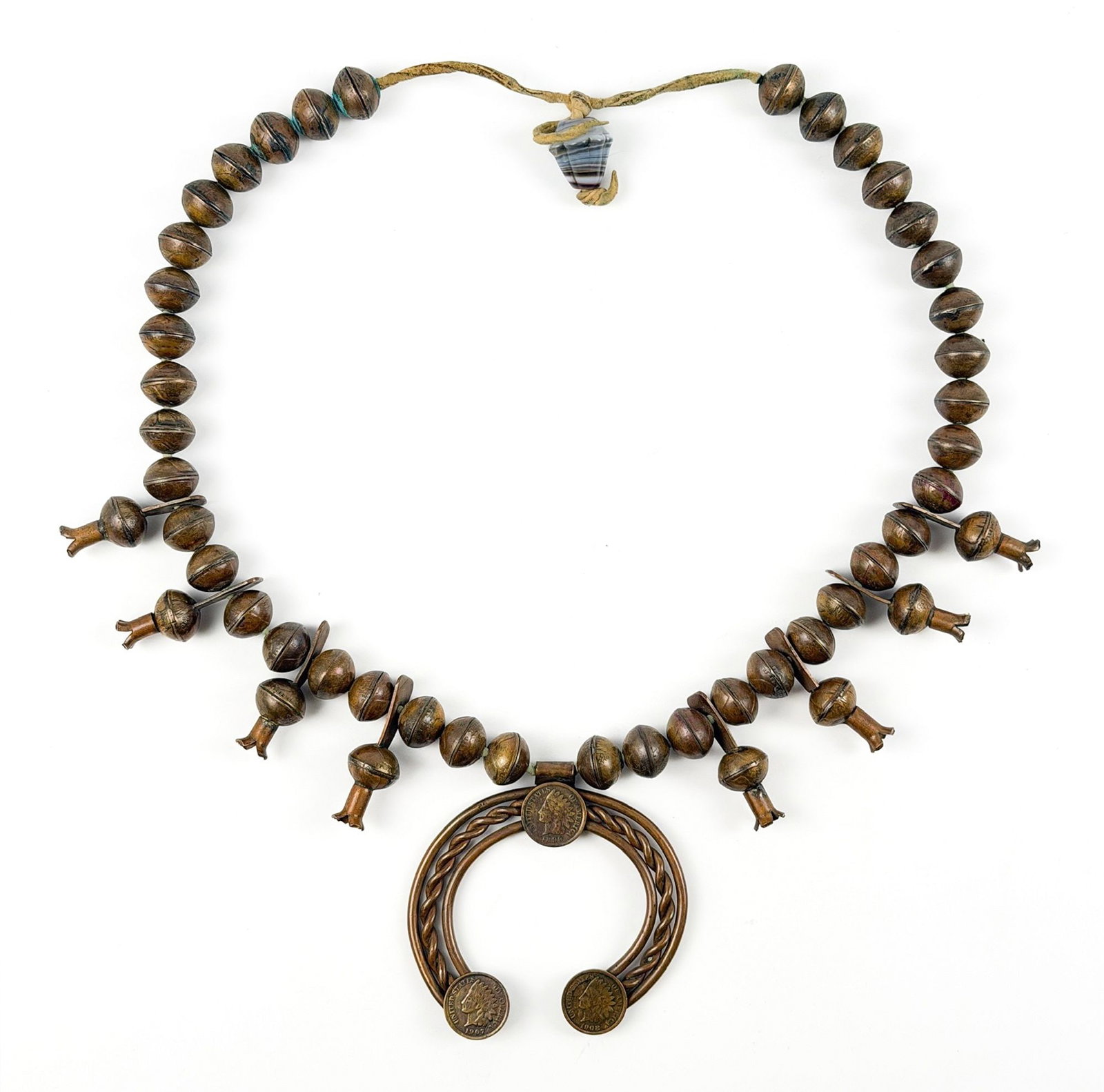 Navajo Style Copper Squash Blossom Necklace with Indian Head Cents: A squash blossom necklace in the Navajo style in copper. The naja and beads are mounted and accented with Indian Head cents (dated 1899 to 1908), strung on a hide cord with a banded bead closure.