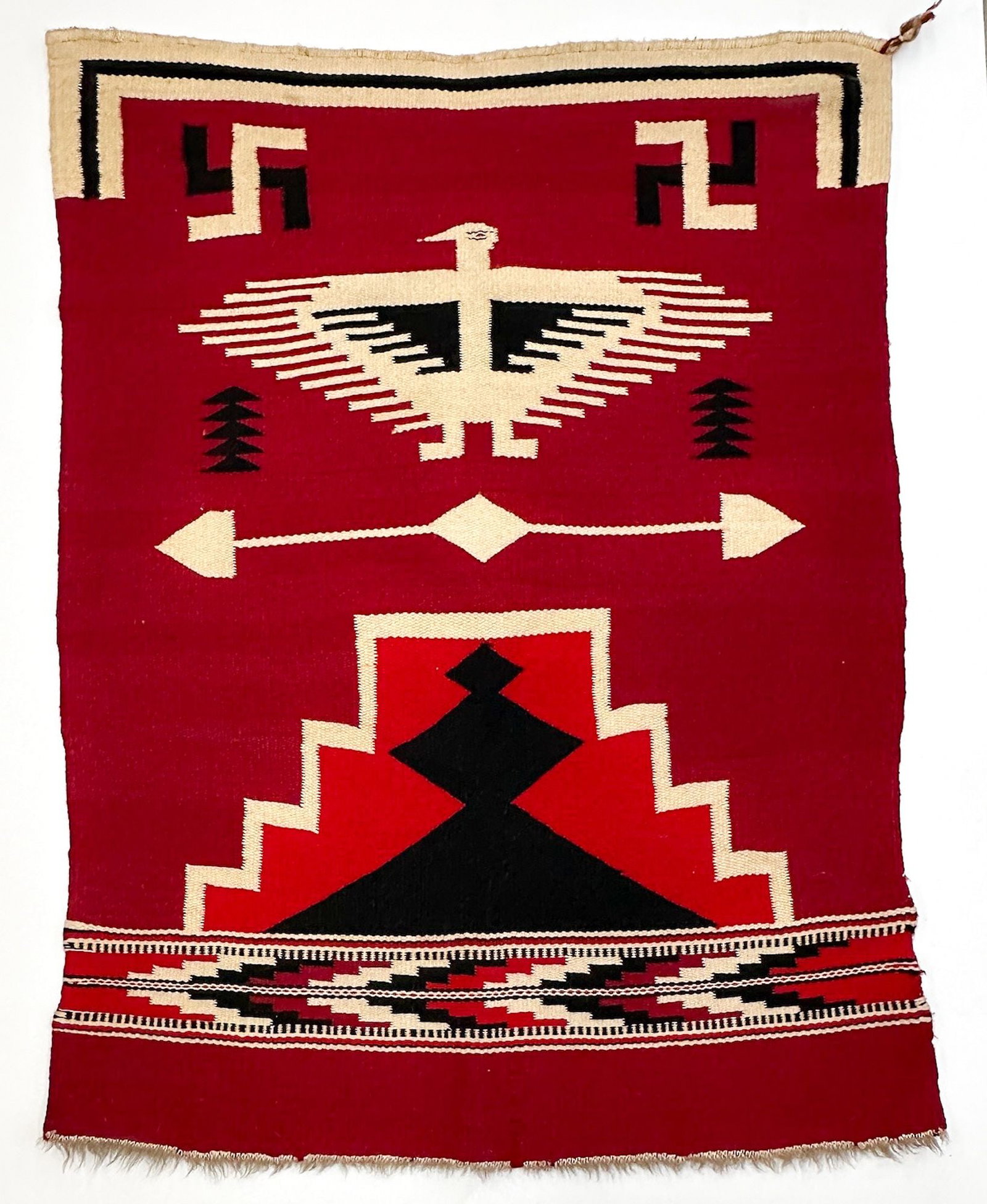 Southwestern Pictorial Weaving, Thunderbird and Whirling Log Design: Rug with red, black and off white tones. Thunderbird motif. Fred Harvey era tourist style, circa 1920s to 1930s.Dimensions: Rug is approx. 49.75 in H x 38 in W. Weighs 3 lbs 6 oz. LOCAL PICK UP INFORM