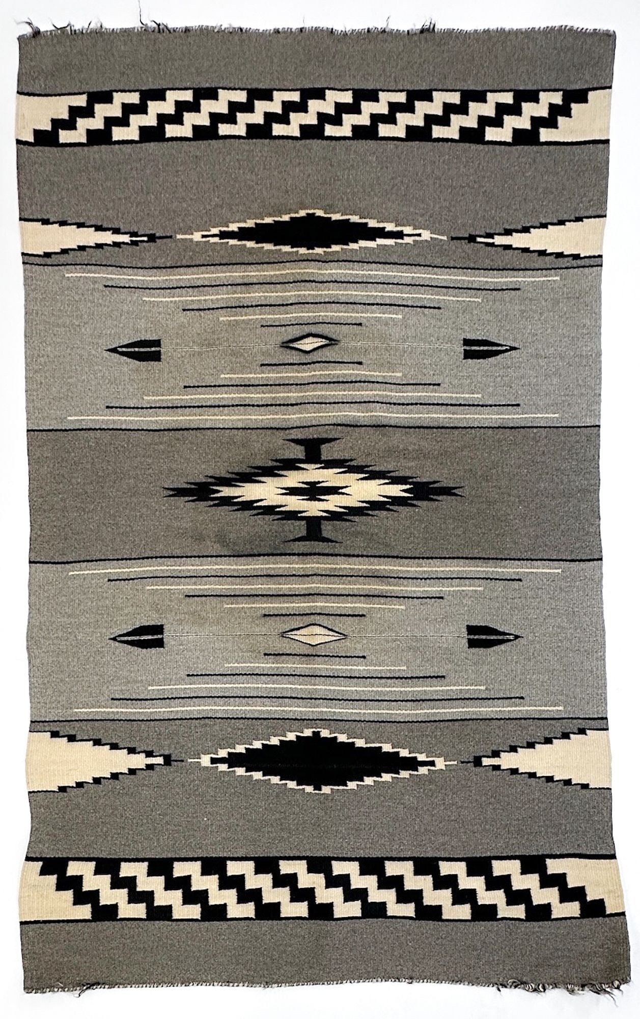 Navajo Gray-Ground Wool Rug, Banded Geometric Design: Wool rug with geometric shapes. Black, white and gray color. Dimensions: 67in H x 42.5 in W. Weighs 4 lbs 2 oz. LOCAL PICK UP INFORMATION: Wednesday, July 8, 10:00 AM - 2:00 PM 8059 Foothill Blvd, Sun