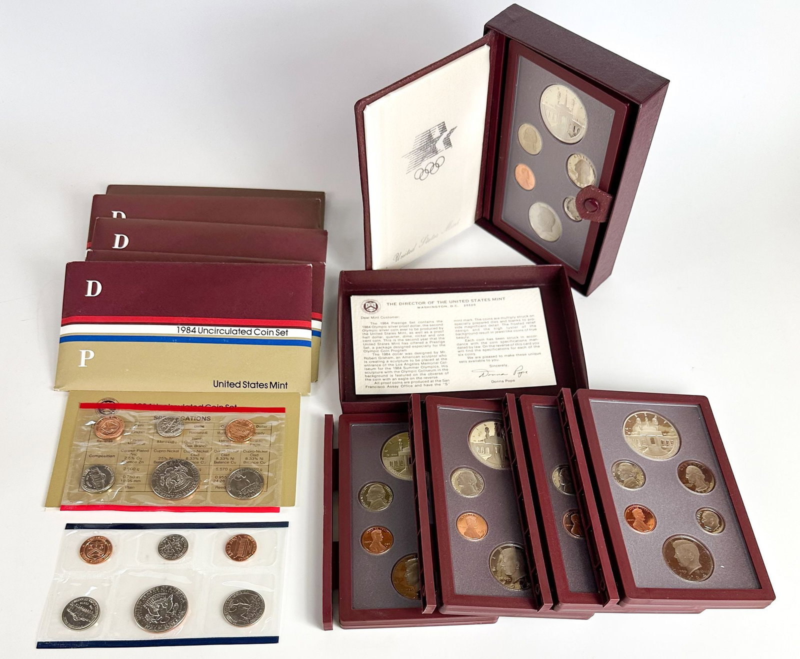 Lot of 10 1984 Olympic Silver Dollars, Mint Sets & Prestige Sets: A group of ten 1984 Olympic items: five uncirculated mint sets and five Prestige sets with Olympic dollars. Issued for the 1984 Los Angeles Games. Shipping & Handling. All lots won by the same bidder 