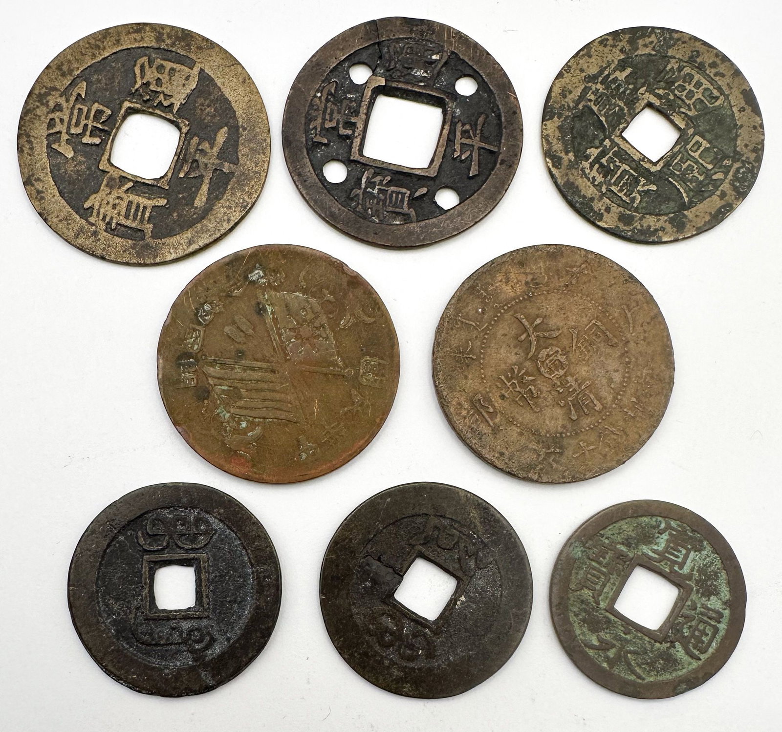 Collector's Lot of 8 Antique Chinese Coins: Eight antique Chinese coins, several with central square holes and dragon or flag motifs. They show age and wear consistent with their history. Shipping & Handling. All lots won by the same bidder are