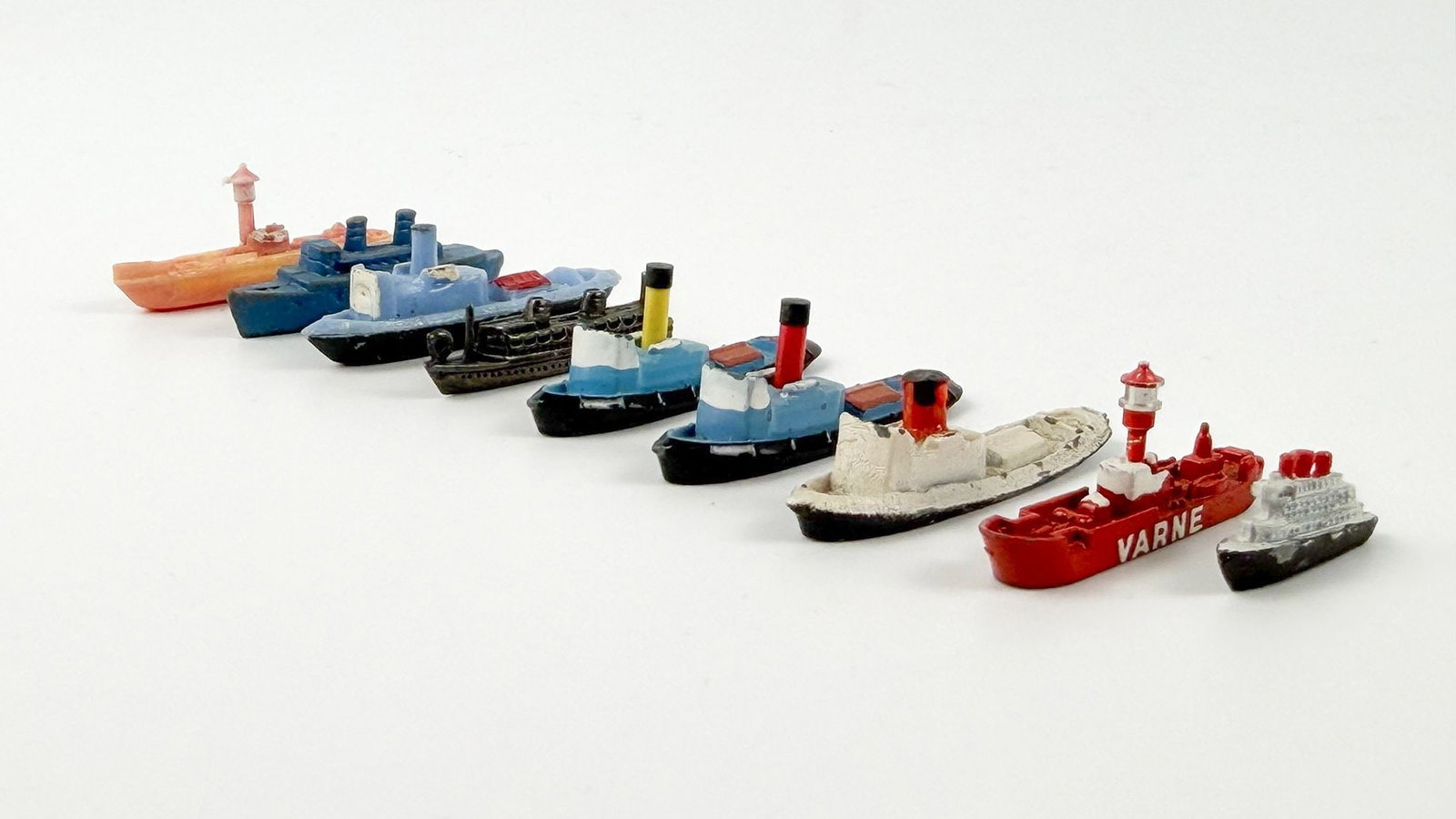 Lot of 9 Miniature Model Ships: Lot includes 4 miniature ships made in England, 2 made in Hong Kong, and 3 that are unmarked. 5 of the ships are made of metal and 2 are plastic. Dimensions: Approx. range: 1.5 in L to 0.5 in L.