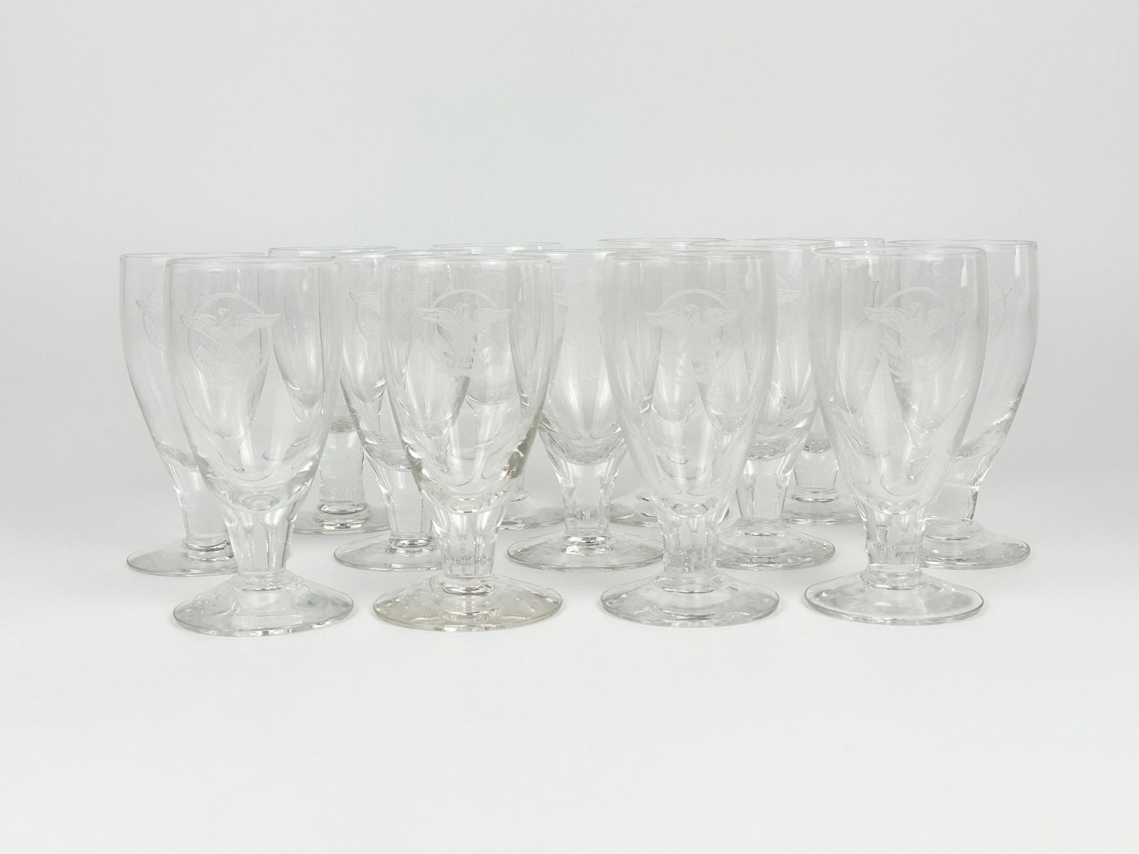 SS United States Wine Glasses w/ US Lines Eagle Logo (13): 13 wine glasses with etched US Lines eagle logo. Dimensions: Each glass is approx. 4 in H x 2.5 in W. Weighs 2 lbs 9oz.