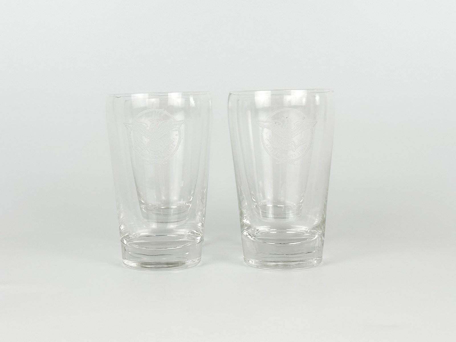 SS United States Juice Tumbler Glasses w/ US Lines Eagle Logo (4): 4 Juice Tumbler Glasses w/ etched US Lines eagle logo. Dimensions: Each glass is 3.75 in H x 2.25 in Dia. Weighs 1 lb.