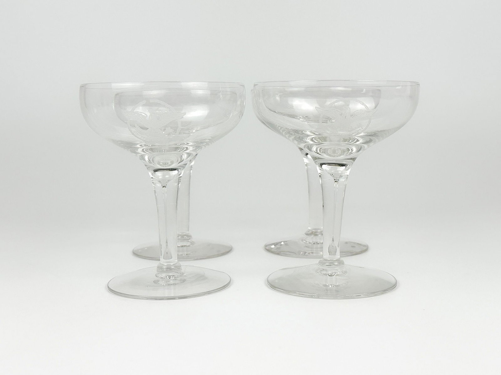 SS United States Champagne Glasses w/ US Lines Eagle Logo (4): 4 Champagne glasses with etched US Lines eagle logo. Dimensions: Each glass is approx. 4.5 in H x 3.75 in W. Weighs 1 lb.