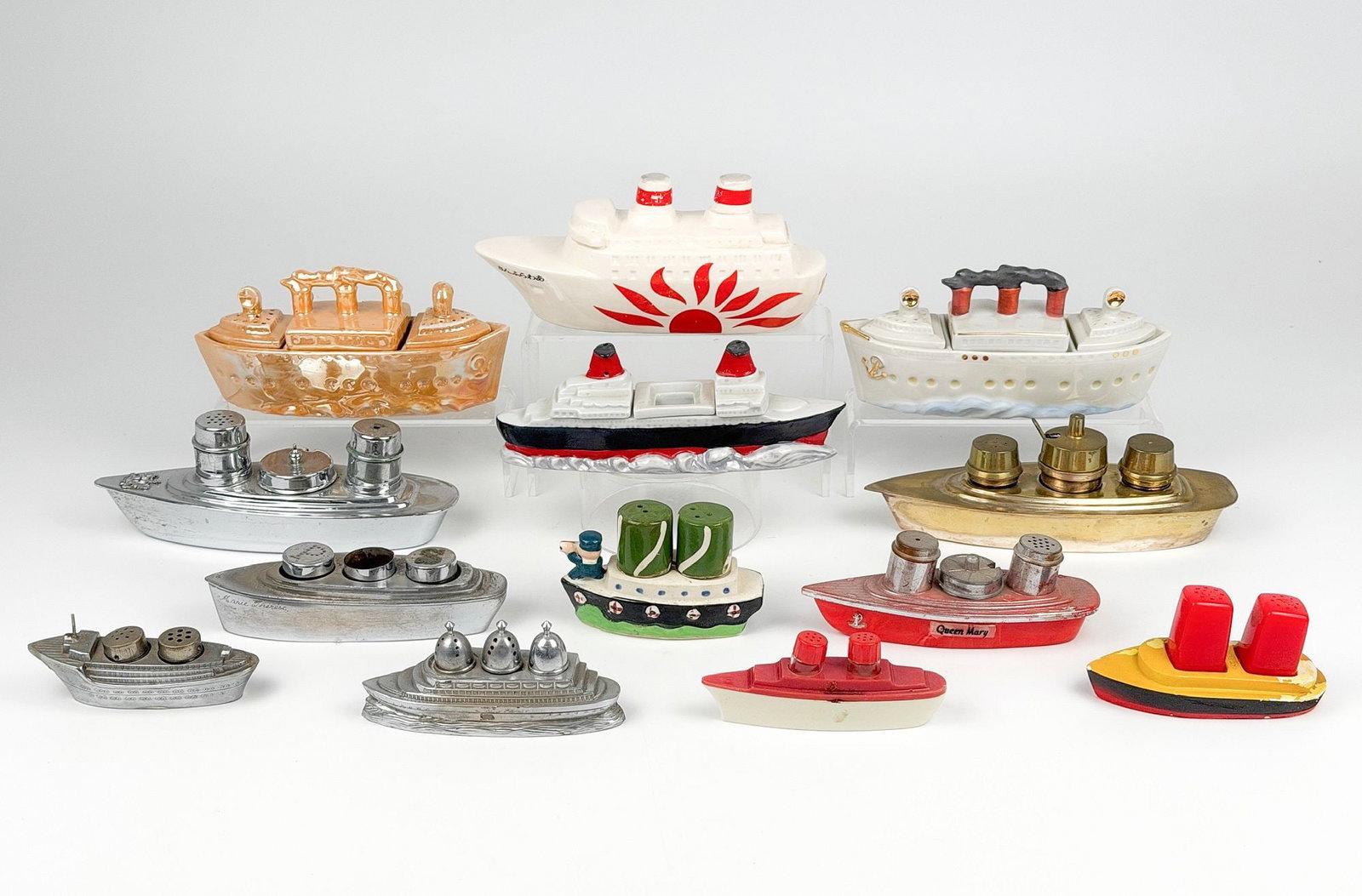 Lot of 13 Vintage Shipliner Salt and Pepper Shakers: Lot includes four ceramic vessels, five metal vessels, and three plastic ones. Japanese vessel in the center back is a coin bank. Dimensions: Sizes range from approximately 1.75 in H x 4.5 in W x 1 in