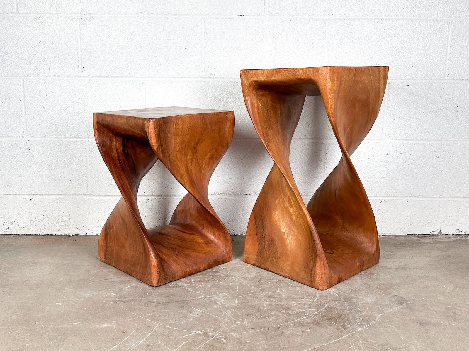 Pair of Haussmann Wood Twist End Tables: Solid piece of wood carved into twisted form. Dimensions: Large end table is approx. 23.25 in H x 12 in W x 12 in D. Small end table is approx. 18.25 in H x 11.75 in W x 11.75 in D. Overall weight: 44