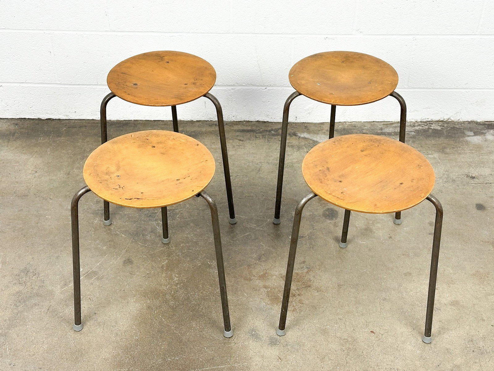 Set of Four Midcentury Danish Teak and Metal Stools: Beveled thin teak wood seats on three welded metal legs. Only one has Made in Denmark stamp on bottom. Dimensions: Each stool is approx. 17.5 in H x 13 in Dia. LOCAL PICK UP INFORMATION:Wednesday, Sep