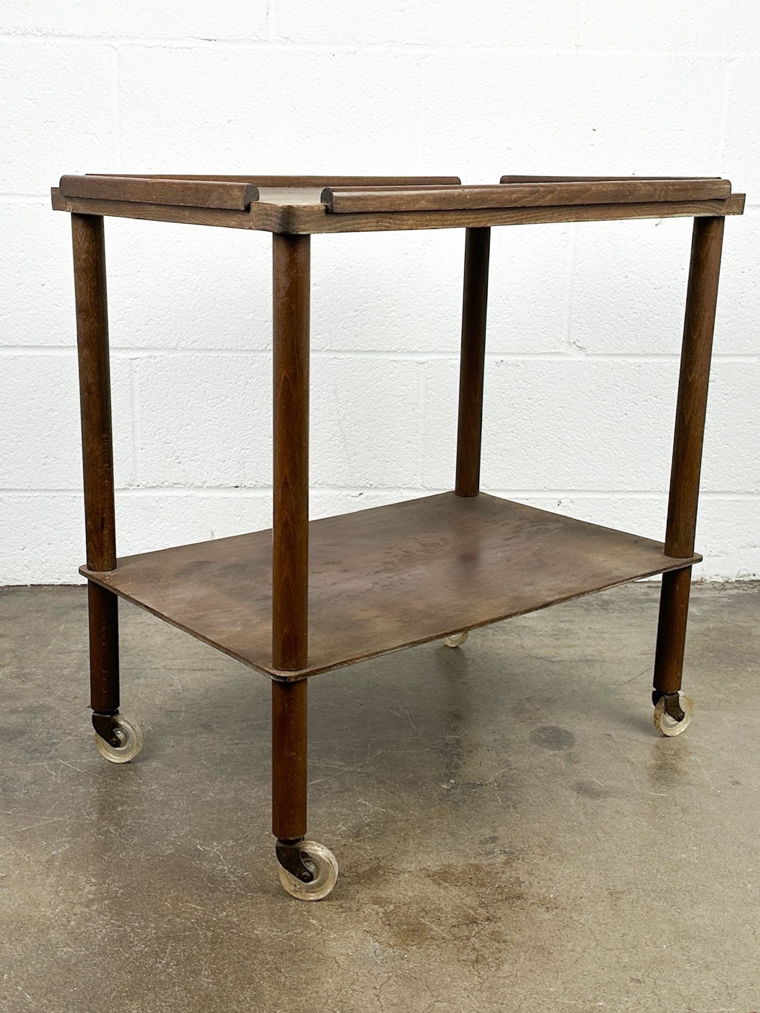 Nevco Midcentury Two Tiered Rolling Tea Cart: Authentic midcentury piece. Stamp on underside. Original casters. Dimensions: Table is approx. 23.5 in H x 22.5 in W x 15.5 in D. LOCAL PICK UP INFORMATION:Wednesday, September 16, 10:00 AM-2:00 PM at