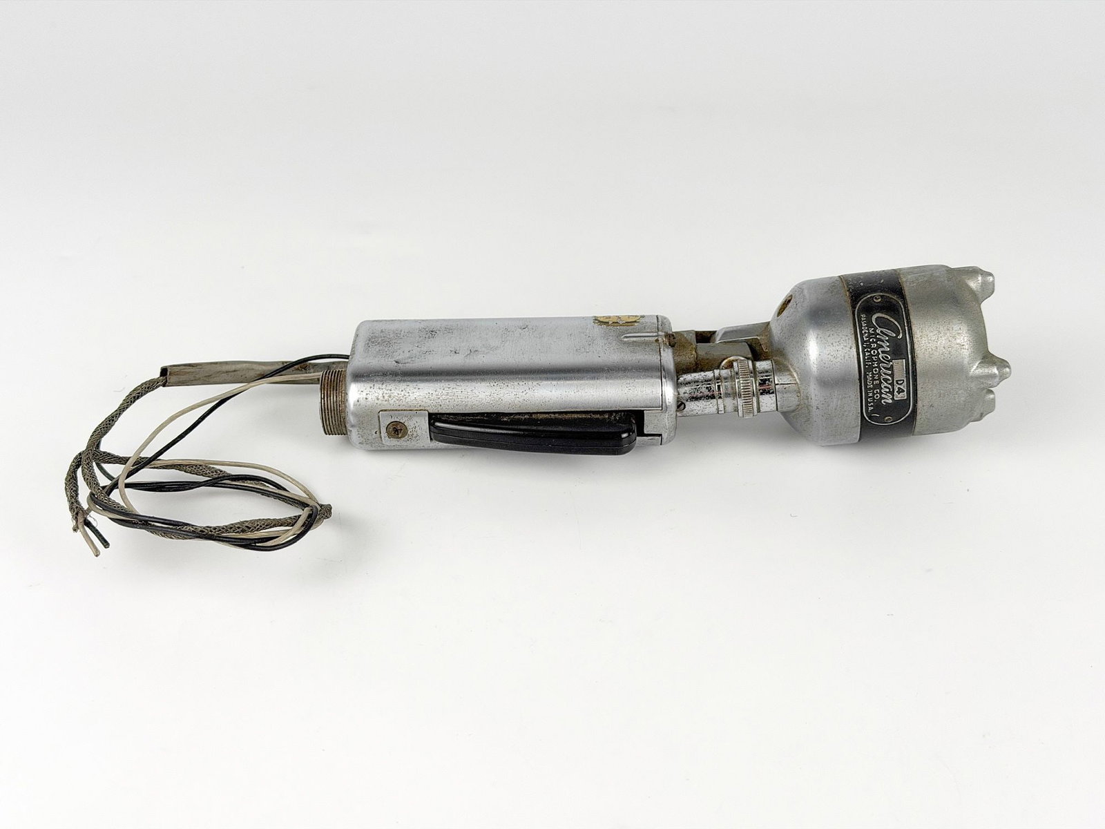 Vintage American D4 Microphone: Microphone features a button for amplification activation. Made by the American Microphone Company in Pasadena, CA. Dimensions: Approx. 8.25 in H x 2.5 in W x 2 in D. Weighs approximately 1 lbs 7 oz. 