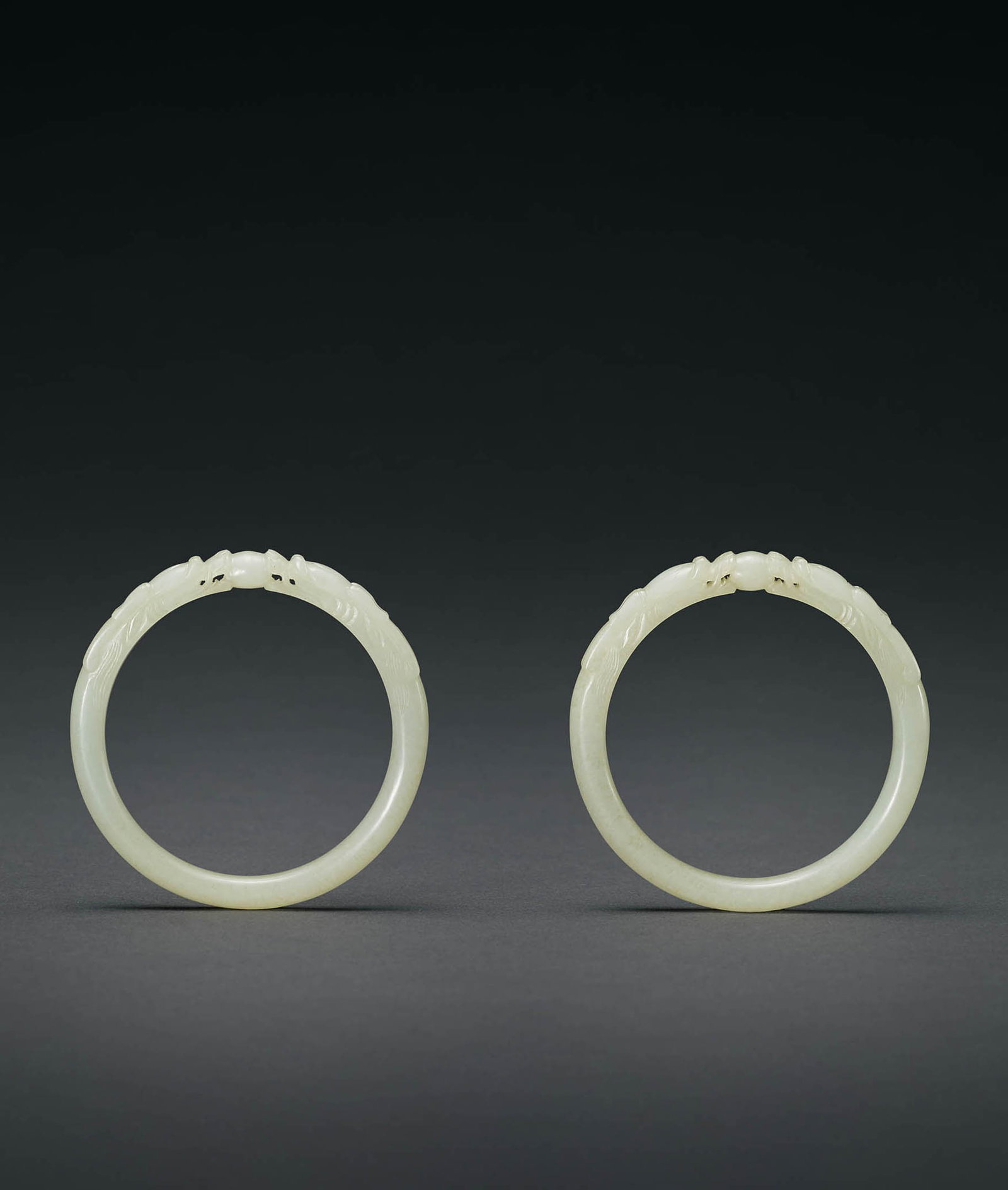Pair White Jade 'Dragon' Bracelets, Qing: 576 清 白玉雙龍搶珠鐲一對 D8cm 鐲環尺寸20.5 預估價： TWD 80,000-120,000 RMB 17,400-26,100 Yu