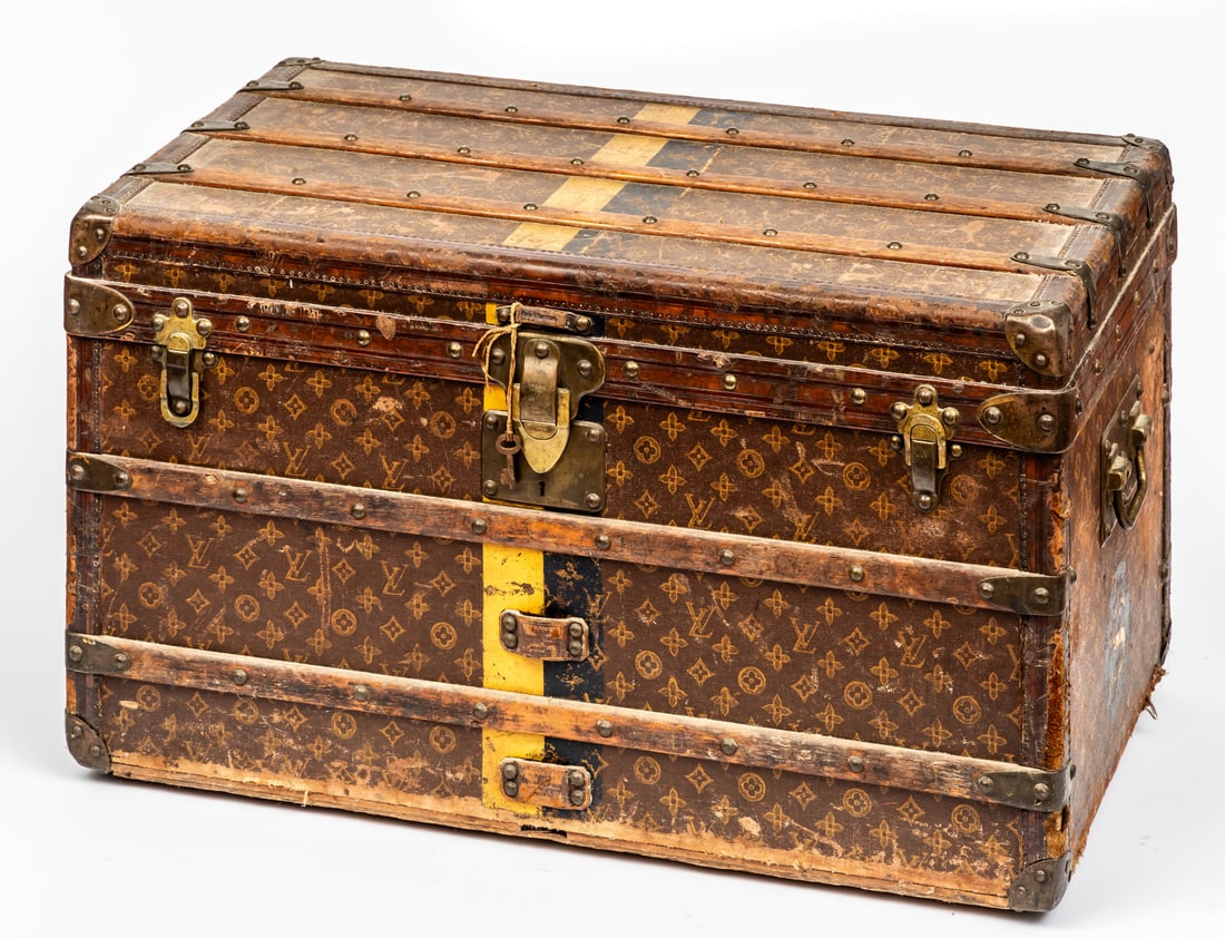 LOUIS VUITTON MAIL TRUNK: made of wood, covered in monogram canvas with leather, brass and wood reinforcements, two side handles, bottom with wheels. Inside there is a paper label, next to it the identification number 165219.