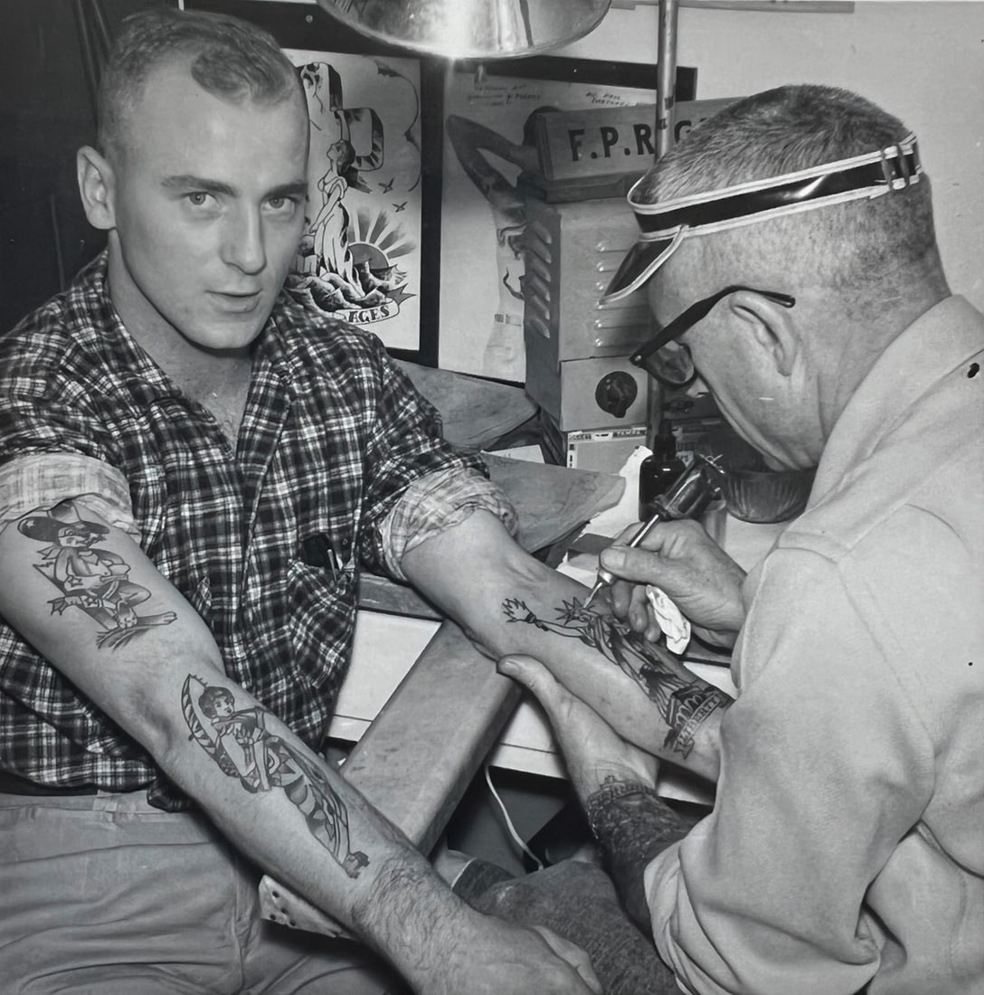 Franklin Paul Rogers (Tätowierer, 1905-1990): Paul Rogers tattooing a guy on left arm. Foto, Nov. 1974, Kodak Paper, USA 8.8 x 8.8 cm Franklin Paul Rogers (1905-1990) was an American tattoo artist and one of the forefathers and pioneers of Americ