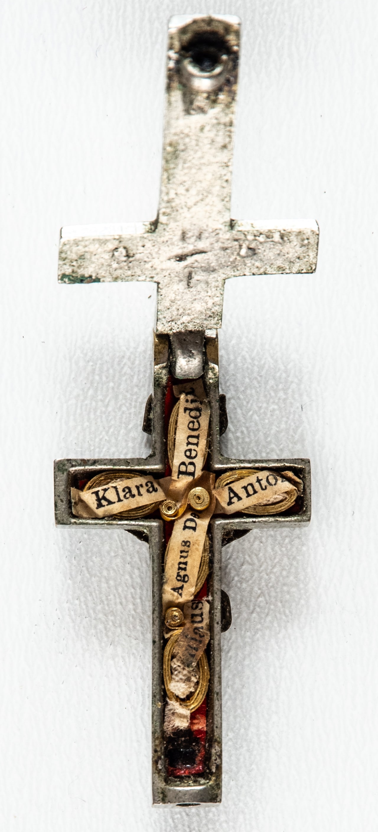 VERY SMALL CROSS WITH RELICS: Metal, hinged compartment with relics, screw at the bottom for closing missing, circa 1900 H: 4.7 cm