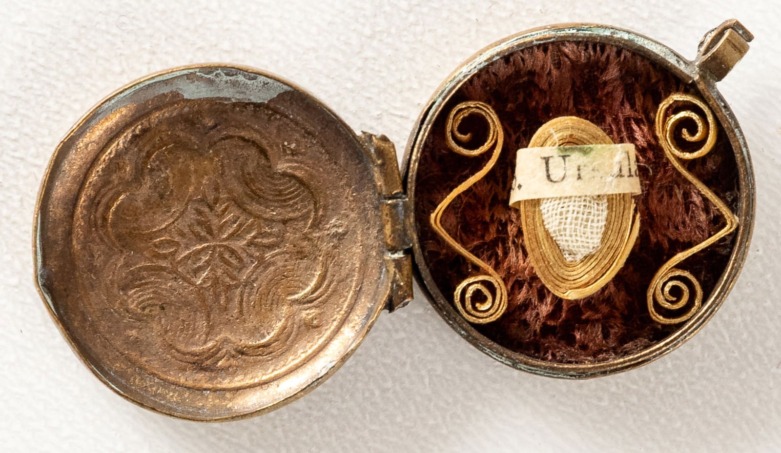 MEDALLION WITH RELIC OF ST. URSULA: Round copper pendant with a relic inside, probably 19th c. D: 2 cm, H: 0.8 cm