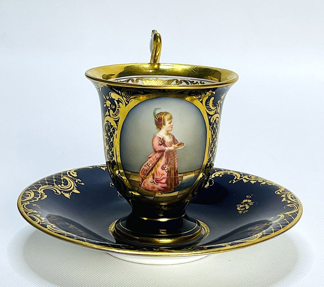 Beautiful Dresden Porcelain Cup & Saucer Hand-Painted: Beautiful Dresden Porcelain Cup & Saucer Hand-Painted in Cobalt Blue with 24k Gold Leaf, recreating the image of a lady of the time. 4.25" H (in). Germany.