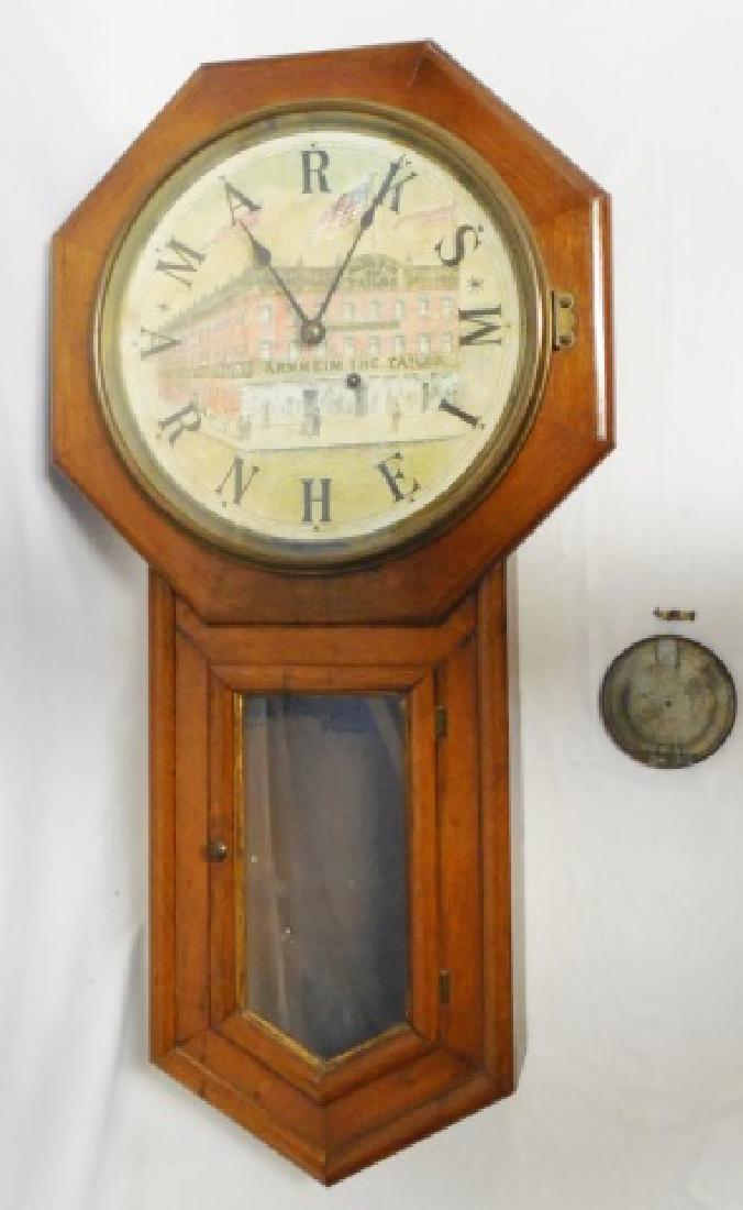 "Seth Thomas" Wall Clock: features "Arnheim the Tailor" building on face of clock and measures 32" L NOTE: DAMAGE TO CLOCK IS PRESENT INCLUDING BROKEN PENDULUM