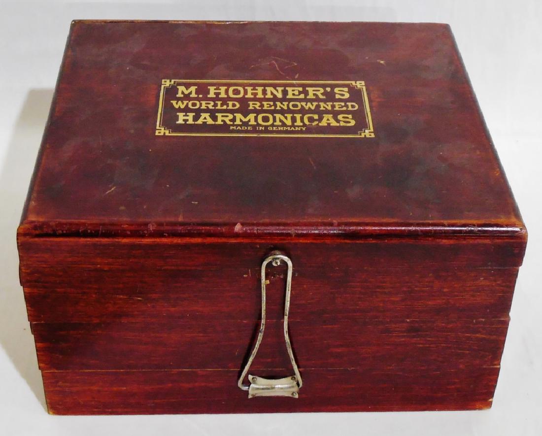 M. Hohner's World Renowned Harmonicas Display: case with harmonicas, Made in Germany, when opened measures 25" L x 11" W x 14" H, NOTE: THE TOP IS DAMAGED