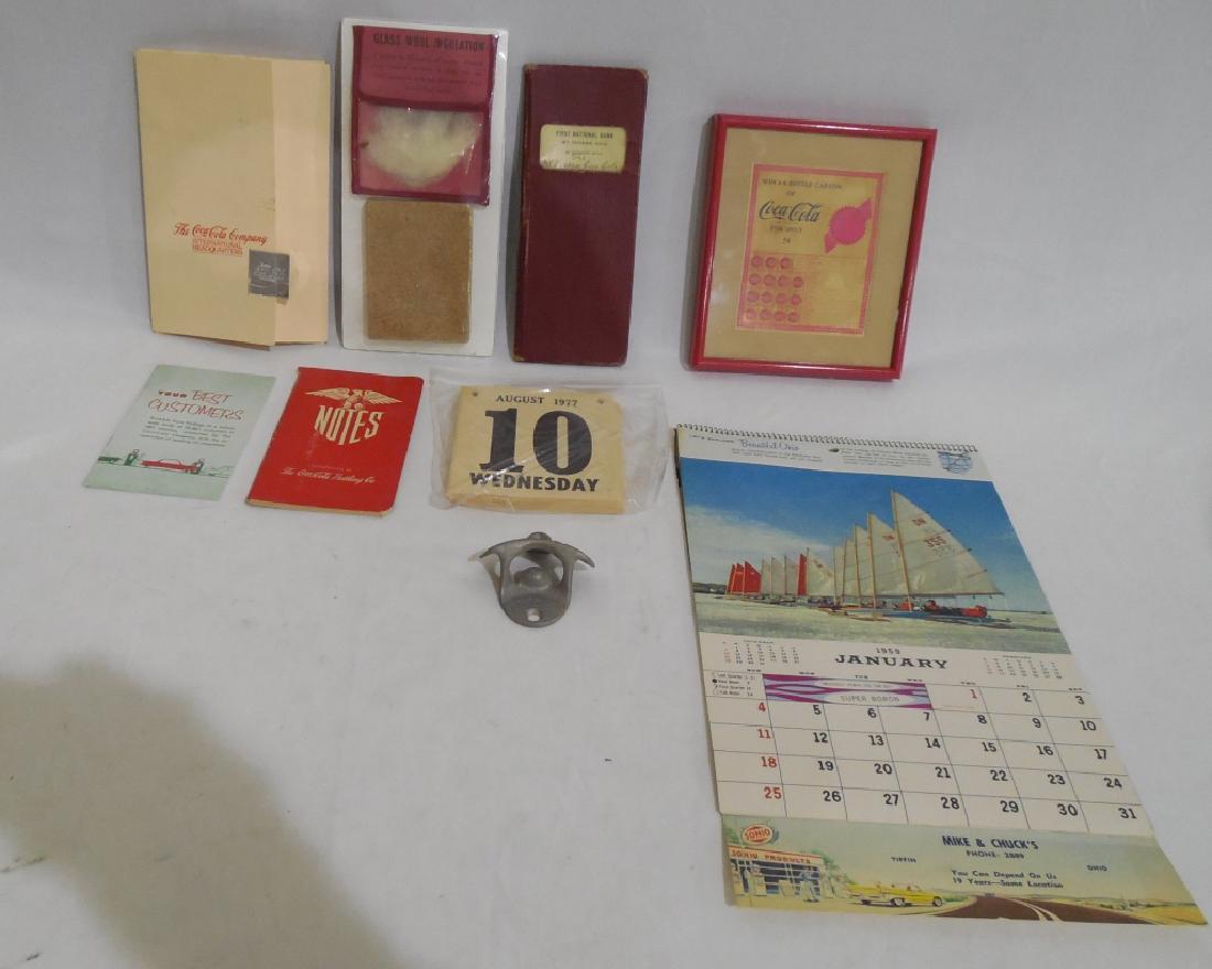 Assorted Coca Cola Collectibles Lot: calendar, notebooks, cooler insulation sample, post cards, bottle opener, and push board