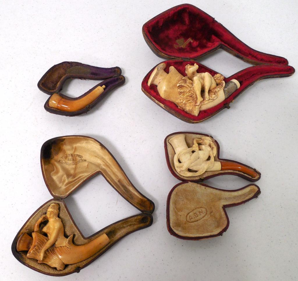 4 possibly hand carved pipes in various cond. three: three pipes are missing tips, one pipe has a broken foot, one pipe has a chip in carving, three cases are labelled Meerschaum, one case is broken