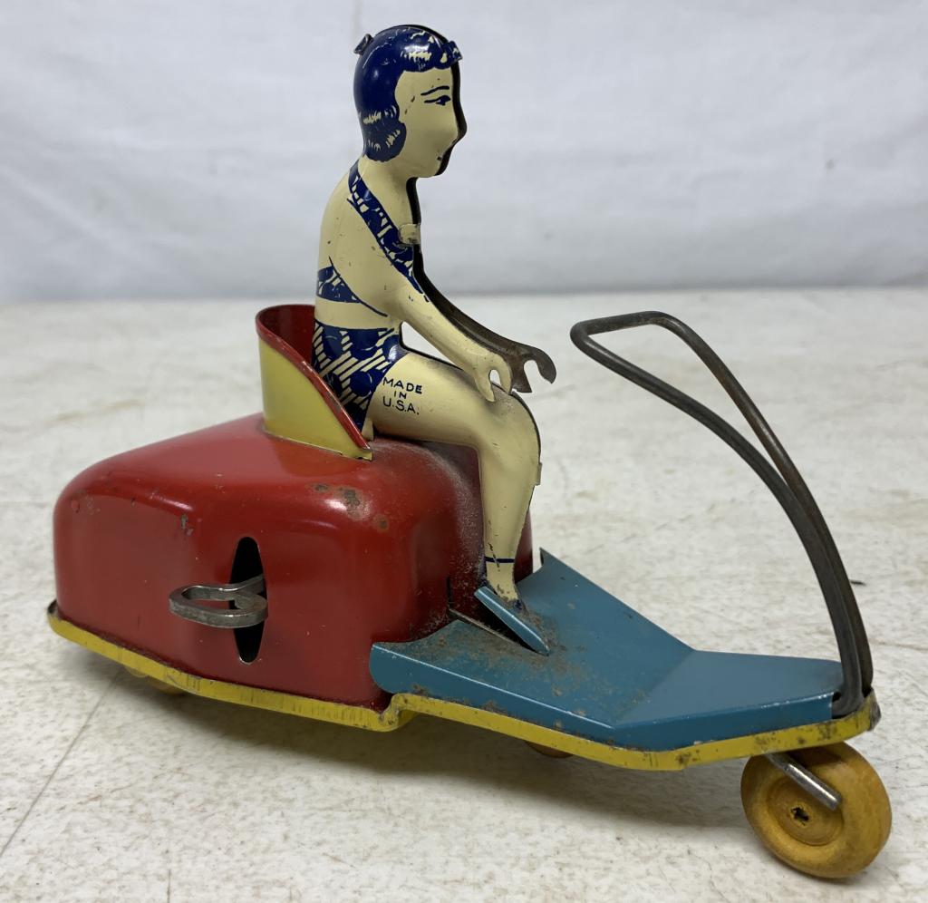 Tin Litho Woman on Scooter Wind Up Toy: windup mechanism untested, stamped made in USA, no other names on toy but might be Courtland, front axle is not connected to the wheel, scratches on her one leg and at spots of scotter