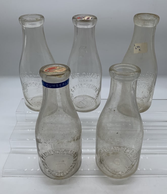 5 Parthemore New Cumberland qt. milk bottles: various versions, all embossed quart bottles showing wear and scratches