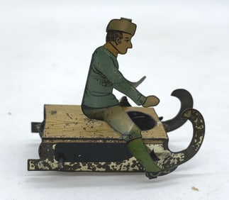 early French man on sled tin litho penny toy
