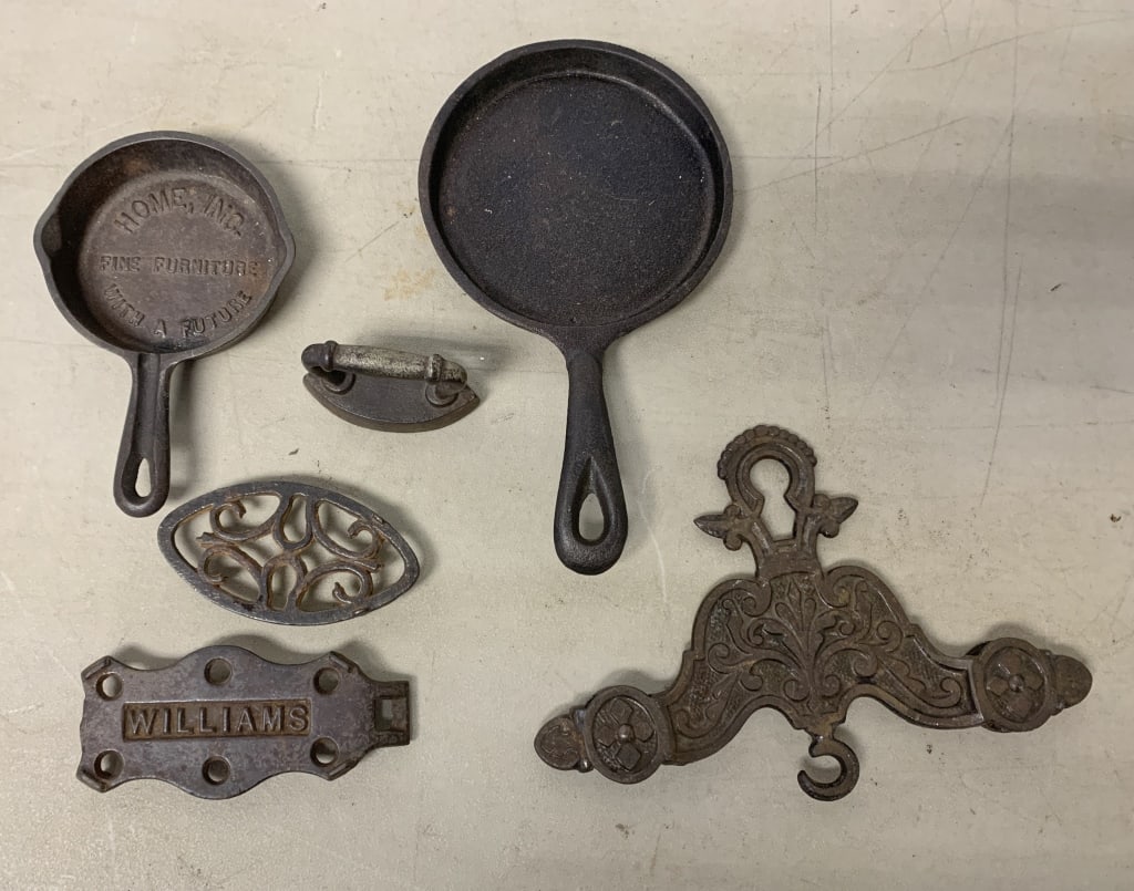 cast iron pulley, frying pans, trivets and iron: unusual double pulley hook, adv. Trivet and frying pan; some rust