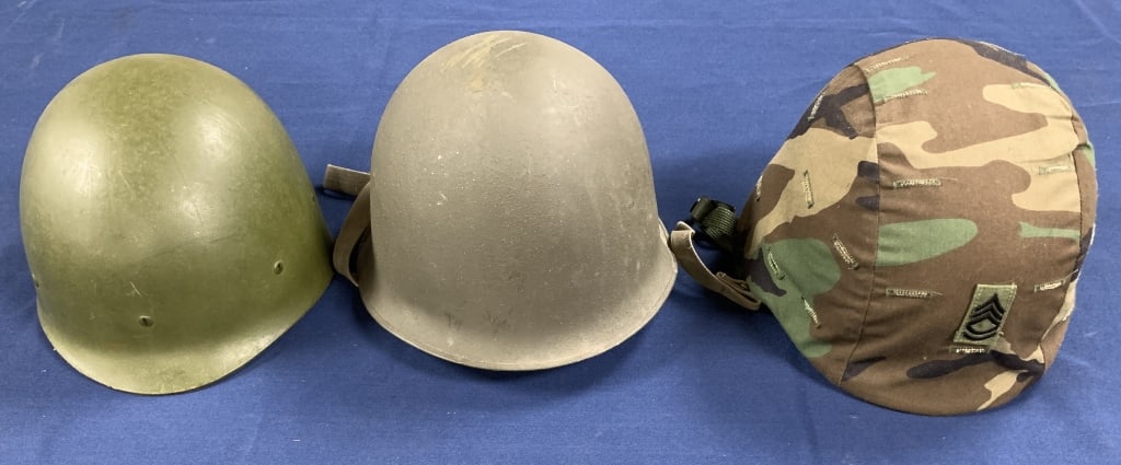 lot of 3 Military Steel Helmets: one with a cloth covering with a sergeant emblem, one stamped Carpentier Gusset 1938, one labeled Ground Troops Helmet Combat Type I, all with some age
