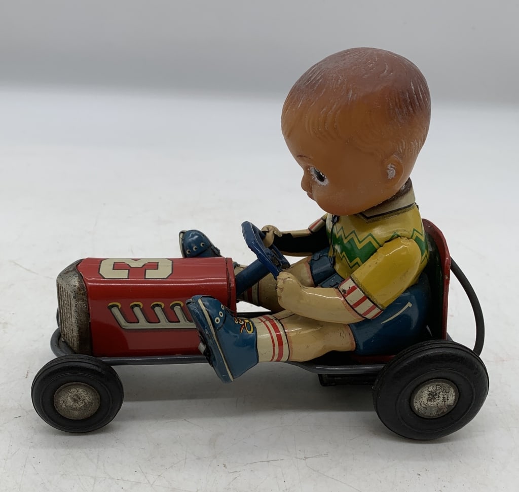 Japanese tin friction boy on go-cart: has wear with some grill rust and plastic needs cleaned; friction drive works