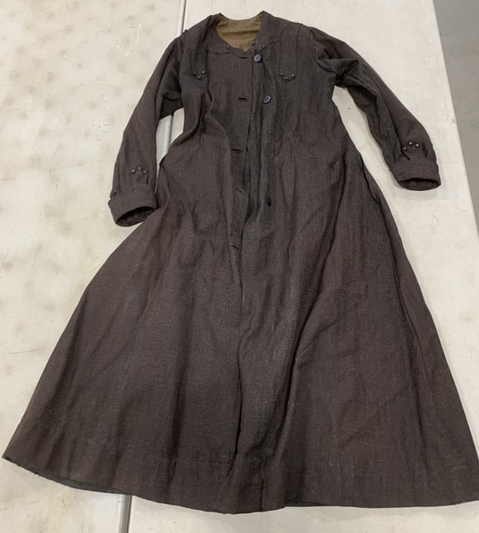 woman's coat: has wear with stains, some holes and missing buttons
