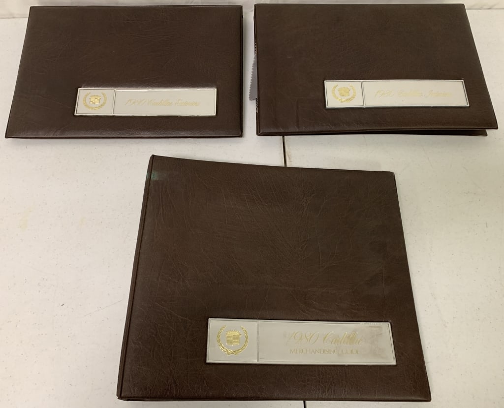3 1980 Cadillac Int./Ext,Merchandising Binders: 1 metal label on front of binder tarnished,some plastic inside torn