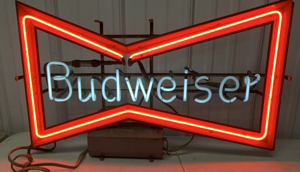 Budweiser neon sigh: 30" wide x 18" tall, has chipped corner, cord to neon is taped; has wear and soiling with rust to frame