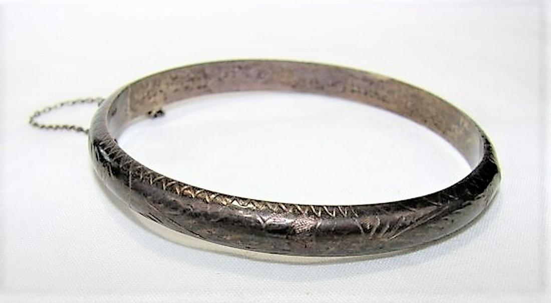 Sterling Silver Bangle Bracelet with Filigree Engraving: 2" across, slide locking clasp and chain, 10.1 grams, heavy patina