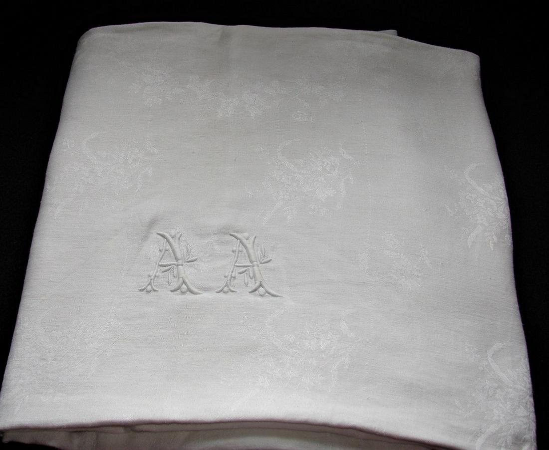 French Damask Tablecloth with Bourdon Embroidered: fine white damask French linen with double "A"A monogram in the center, measures 92" x 64", hemmed on two sides, exposed selvages