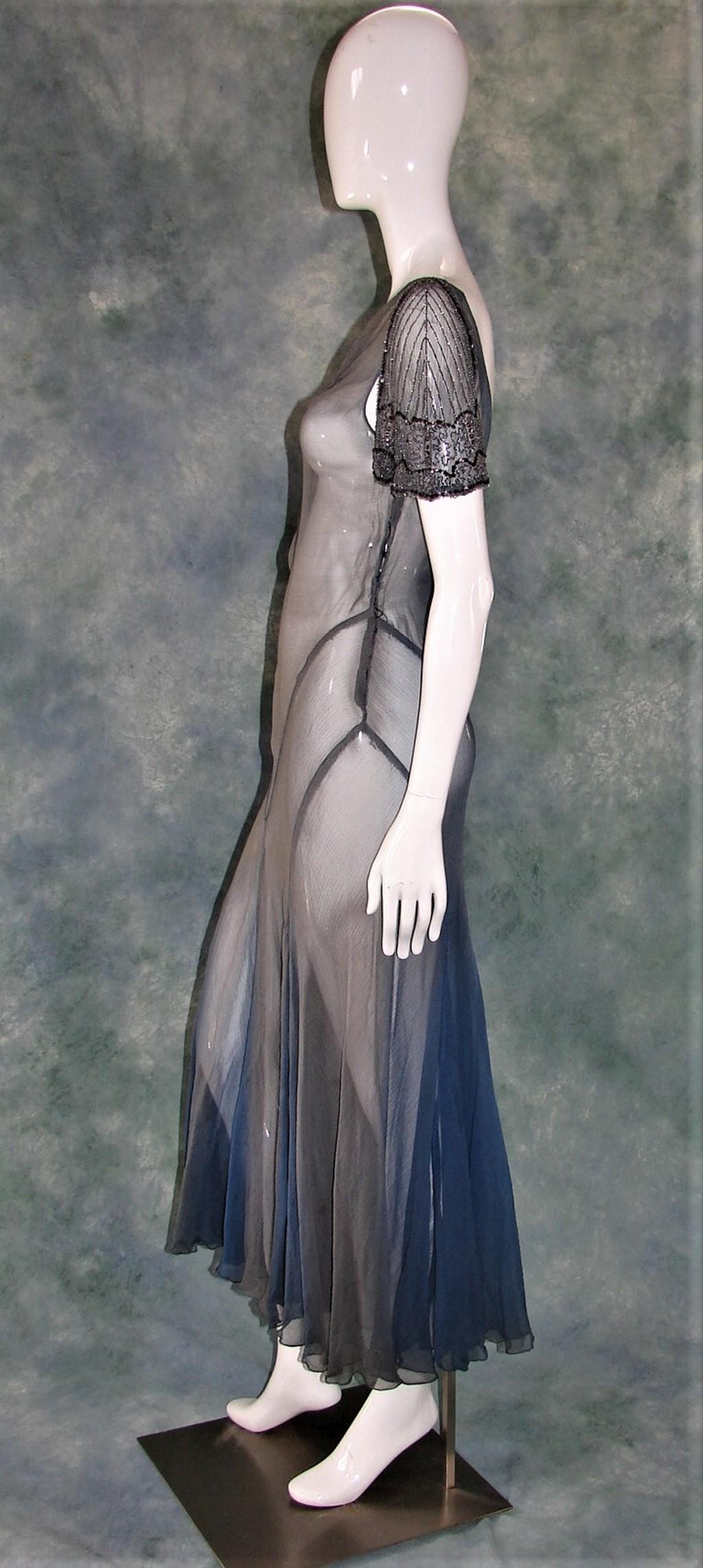 2 Ladies 1930s Long Evening Gowns, Bias Cut: Black silk sheer overdress with a black silk underdress, sewn with chevron details and pin tucks at the shoulders measures 51" long, 32" bust, 30" waist, 32" hips, closes with two metal snaps on the s