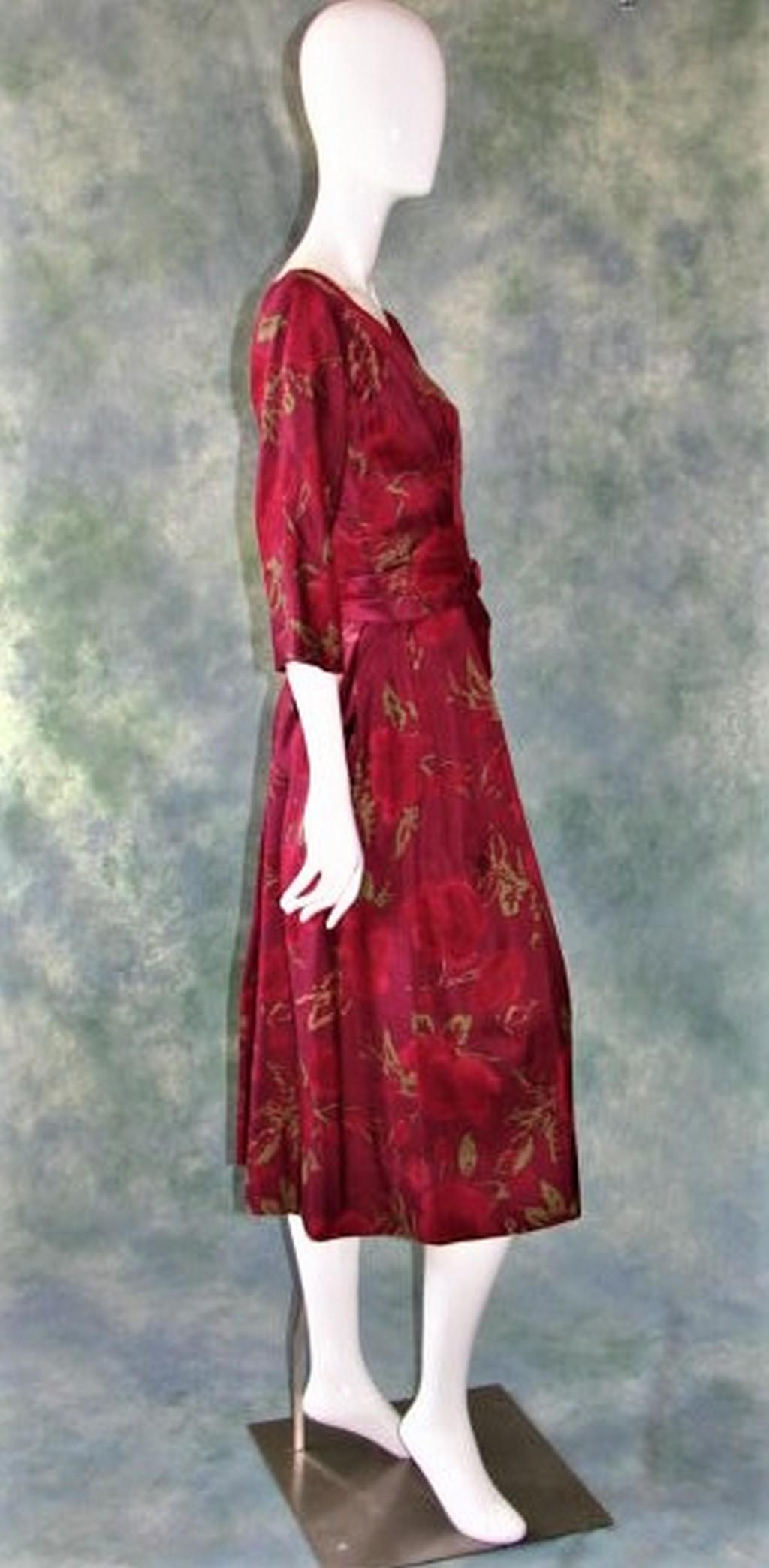 1960's Ladies Suzy Perette New York Red Patterned Silk: Red and green raw silk rose print with a cummerbund style waist, distinctive pleats at waist and all over the skirt, darts and folds throughout. 46" long, 36" bust, 28" waist. Long metal zipper in the