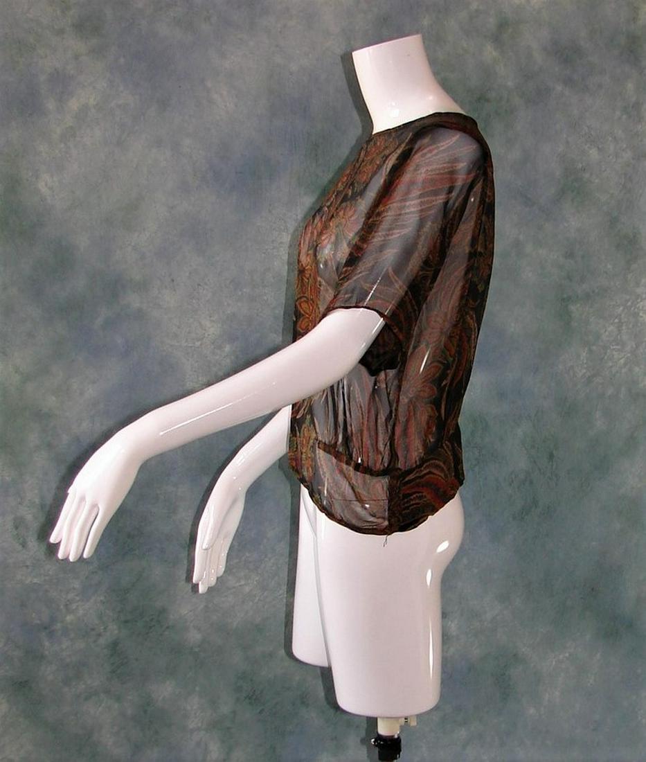 1907 Floral Printed Art Nouveau Black Sheer Silk Blouse: Allover floral print of stylized flowers and leaves in blue, green, gold, red, brown, etc., pleats, four self fabric covered buttons at the waist, measures 18:L x 40"B X 36" W x 17" shoulder to should