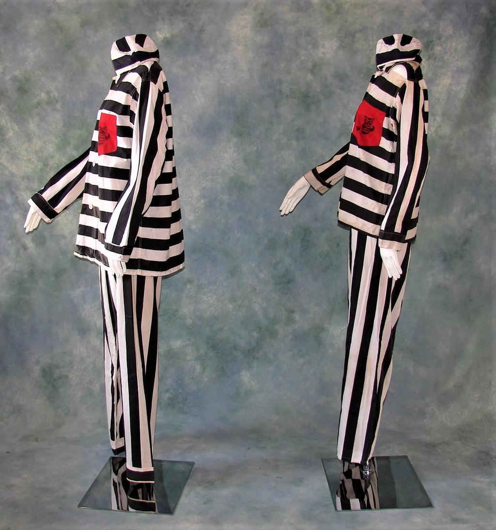 Two 1970's Convict Halloween Costumes His/Hers by: Each costume consists of 3 Pieces (pants, shirt and hat) each with red front pocket with and owl wearing a ball and chain graphic, men's shirt measures 31" long, 20" shoulder to shoulder, 24" across t