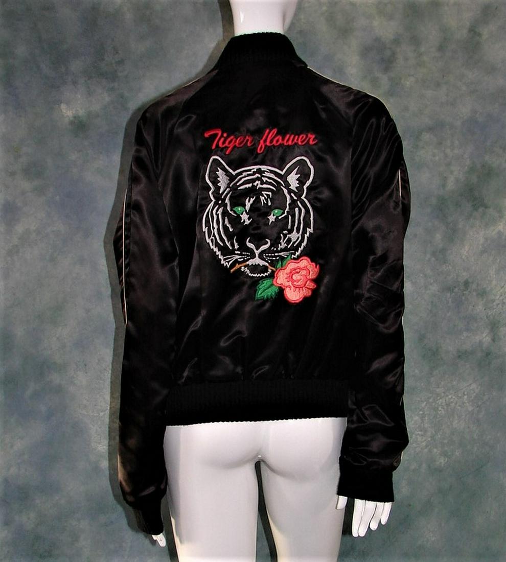 1970s Men's Black Satin Jacket Tiger Flower" Embroidery: shiny black satin, 6 metal snaps in front, woven elastic at waist and wrists, white piping, "Larry" embroidered on front and "Tiger Flower" on back with large tiger and rose, measures 26"L X 22" acros